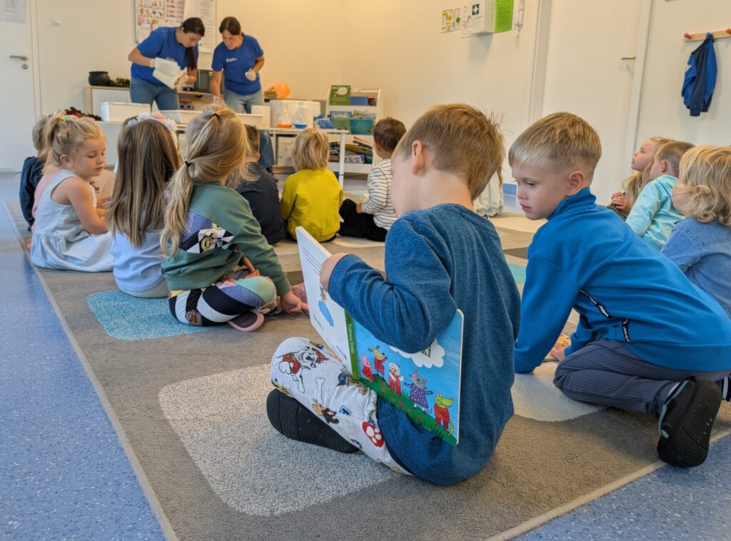 Grupa dzieci w sali dydaktycznej podziwia eksperymenty naukowe wykonywane przez instruktorów.
#DostepnoscCyfrowa